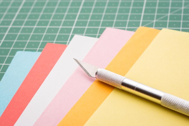 Scalpel on a stack of colorful papers