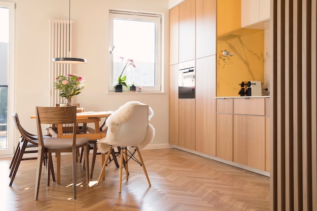 scandi open space interior of kitchen and dining room with family table and kitchen accessories