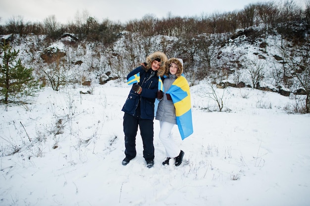 Scandinavian couple with Sweden flag in winter swedish landscape