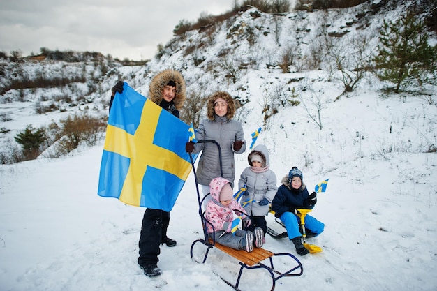 Scandinavian family with Sweden flag in winter swedish landscape