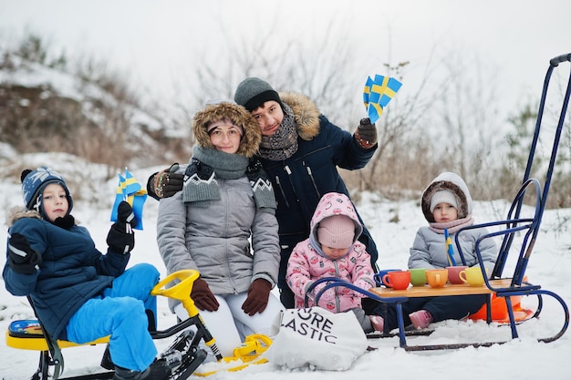 Scandinavian family with Sweden flag in winter swedish landscape