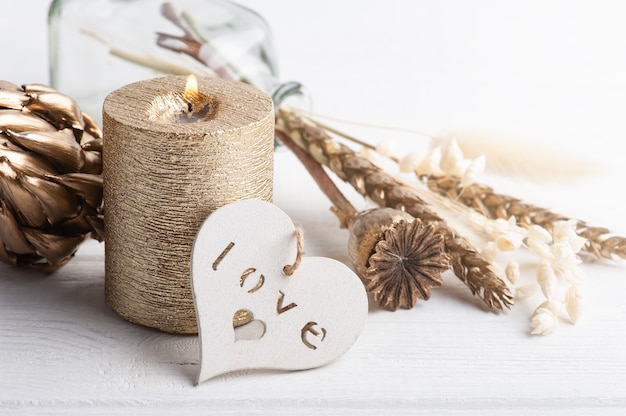 Scandinavian interior with golden dry flowers and lit candle