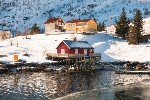 Scandinavian red house with wooden jetty on coastline