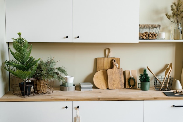 Scandinavian style kitchen utensils Wooden cutting boards wooden spoons and shovels tree in a pot