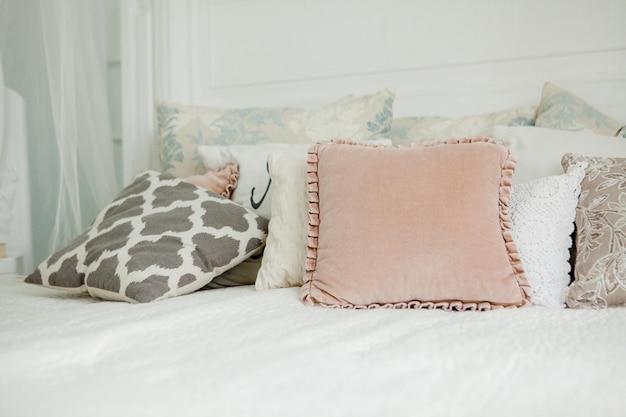 Scandinavian style white bedroom Four pillows are on the bed Modern interior