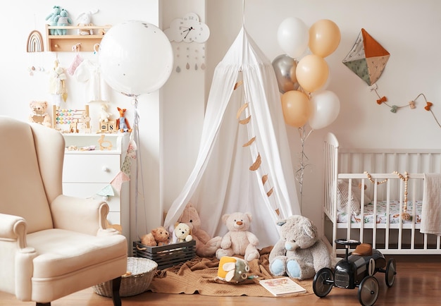 Scandinavian style white interior children's room, bedroom, nursery. Baby cot with canopy. Wooden shelves and toys. Canopy tent, textile kite and balloons