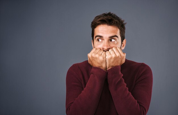 Photo scared afraid and phobia of man in studio anxiety and biting of nails for stress worry and fear gray background mockup space and person with terror for nightmare of fail in test of college