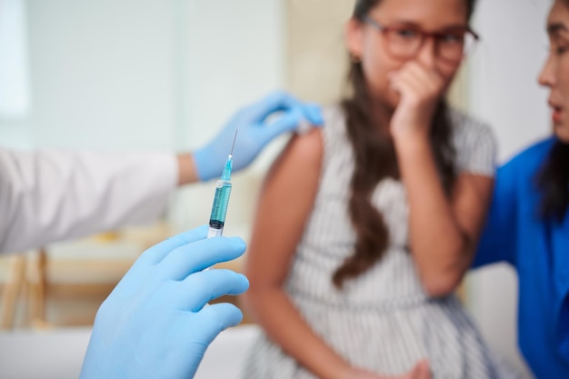 Scared Girl Looking at Syringe