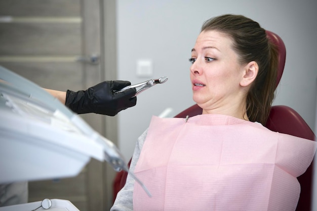 Scared horrified frightened  girl patient with dentist phobia, woman in panic afraid of doctor