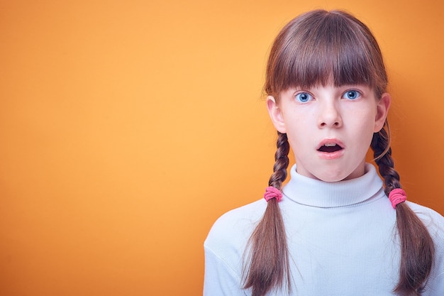 Scared and surprised Caucasian teen girl on colored