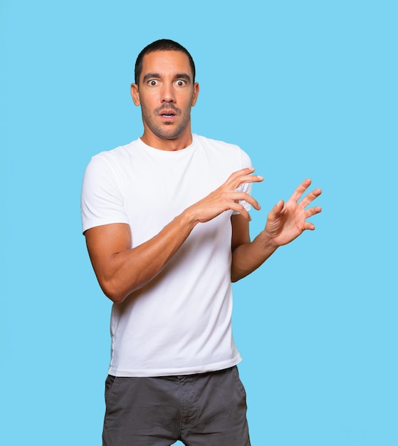 Scared young man screaming against background