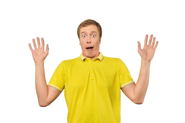 Scared young man with hands up in yellow Polo Tshirt white isolated background