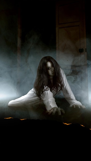 A scary ghost woman crawls on the floor with white smoke background Scary woman Halloween concept