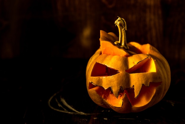 scary halloween pumpkin on black background copy space