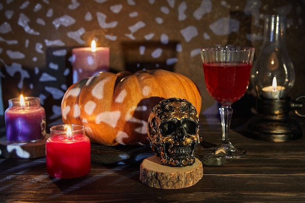 Scary halloween skull with pumpkin and wine on a spooky night. Halloween scene.