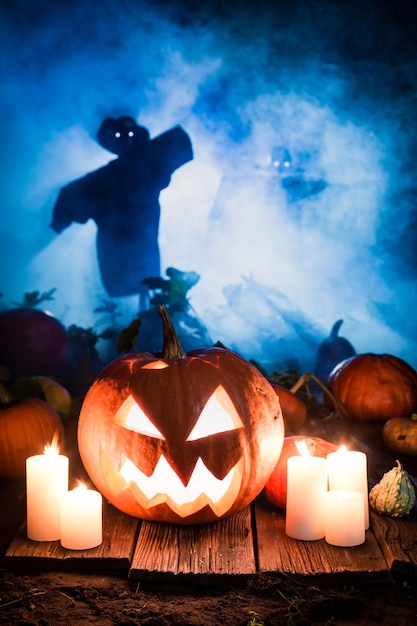 Scary pumpkin with scarecrows on the field for Halloween