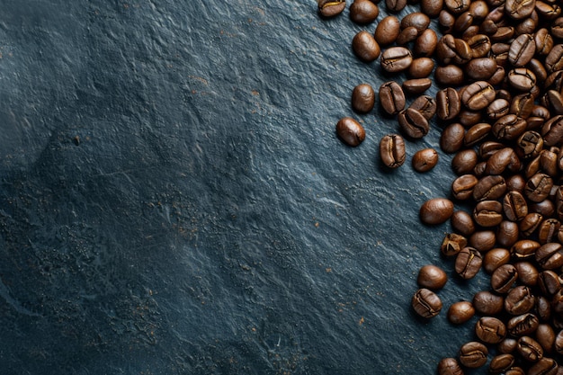 Scattered Coffee Beans on a Textured Dark Slate Background