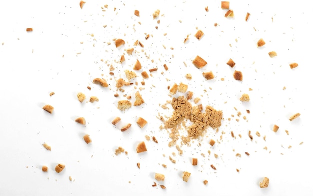 scattered crumbs of roasted white bread on a white background closeup