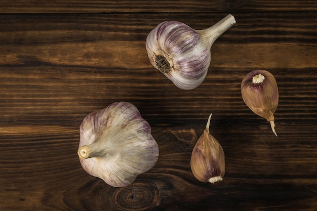 Scattered heads and cloves of garlic on a wooden background