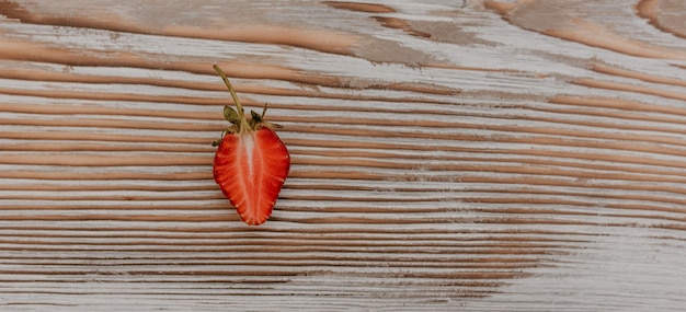 scattered juicy fresh red strawberries on the table with vintage plank.