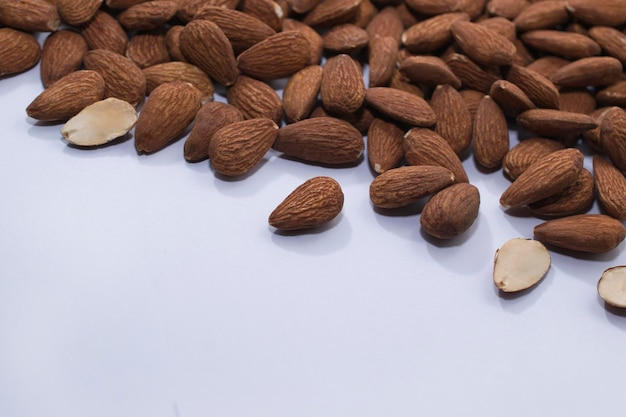 Scattered peeled almonds on a white background