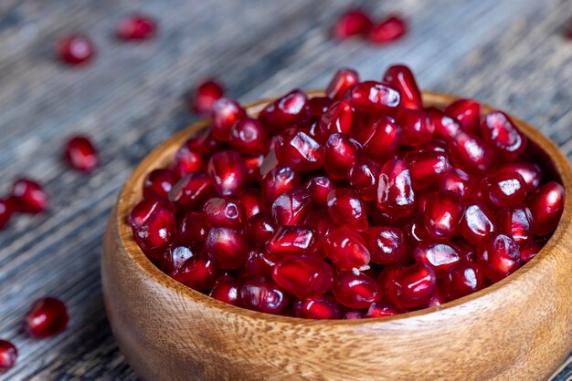 Scattered pomegranate seeds on a wooden board