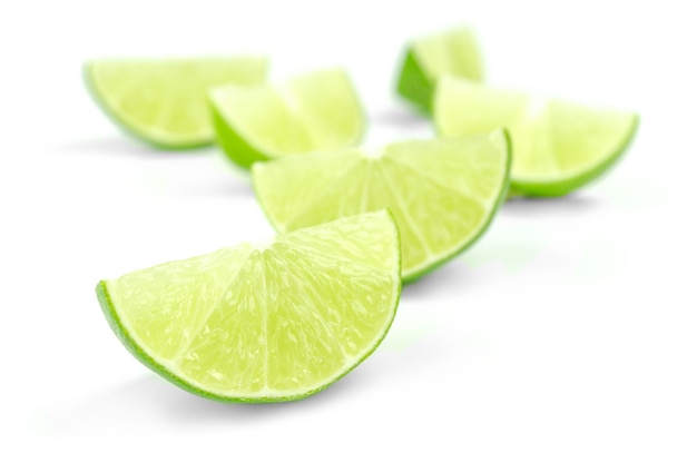 Scattering of fresh lime wedges isolated on white