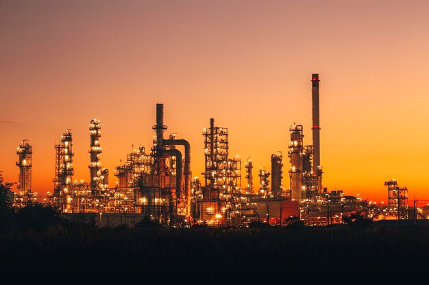 Scene of the oil refinery plant of petrochemistry Oil refinery and plant and flue smoke industry in oil and gas industry with cloud red and orange sky the morning