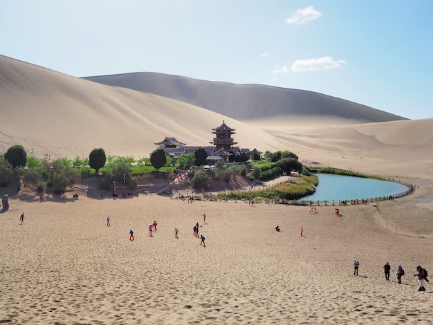 Scenery of crescent-shaped oasis lake and pagoda in Gobi desert, Dunhuang, China.