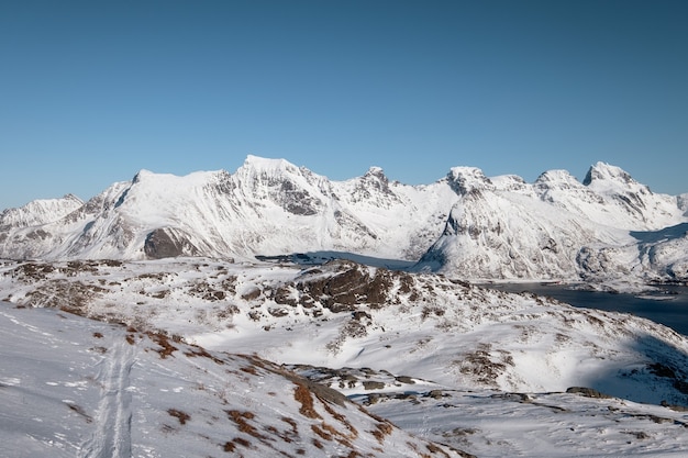 Scenery of snow covered mountain range with blue sky on sunny day at Lofoten islands, Norway