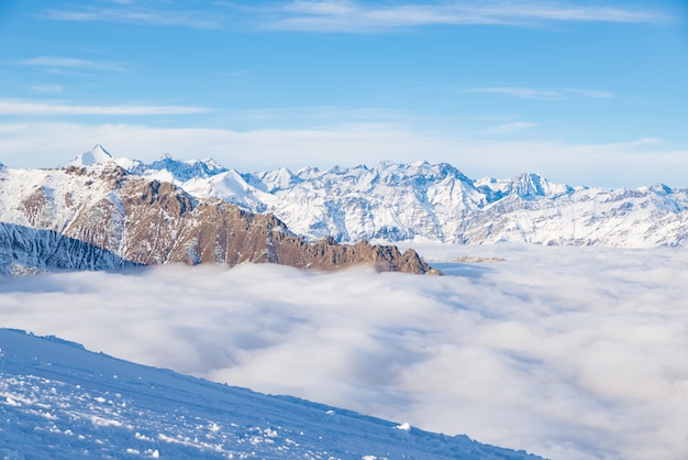 Scenic alpine landscape, clouds on the valley arisign mountain peaks sunset light