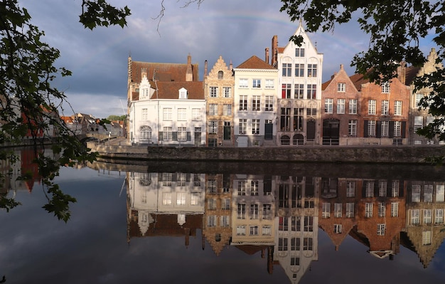 Scenic city view of Bruges canal with beautiful medieval colored houses bridge and reflections at sunny day