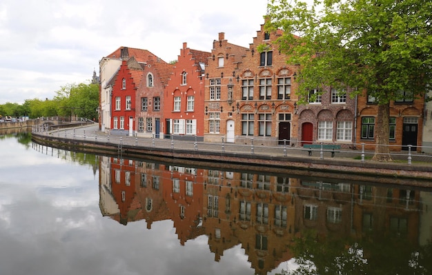 Scenic city view of Bruges canal with beautiful medieval colored houses bridge and reflections at sunny day