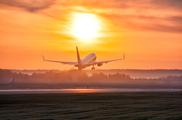 Scenic dawn with a fog at the airport Takeoff of a passenger airplane