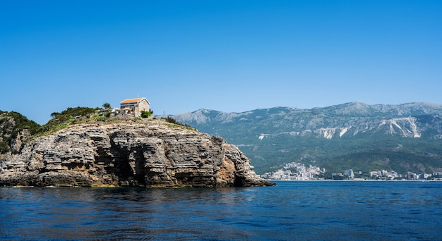 Scenic house on rocks in montenegro with mountains on background amazing mediterranean nature and ar