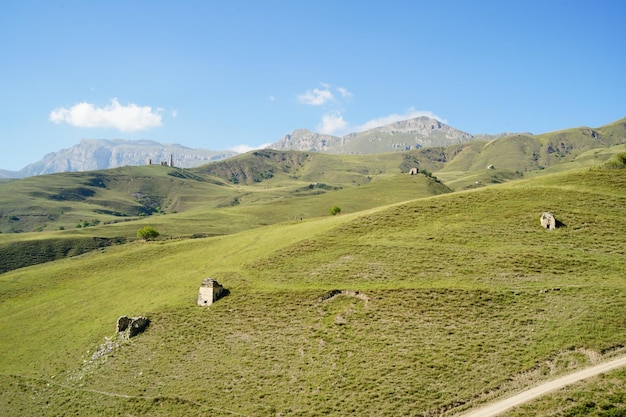 Scenic landscape of mountains in summer Majestic scenery of highland valley with green meadows under blue sky on sunny day