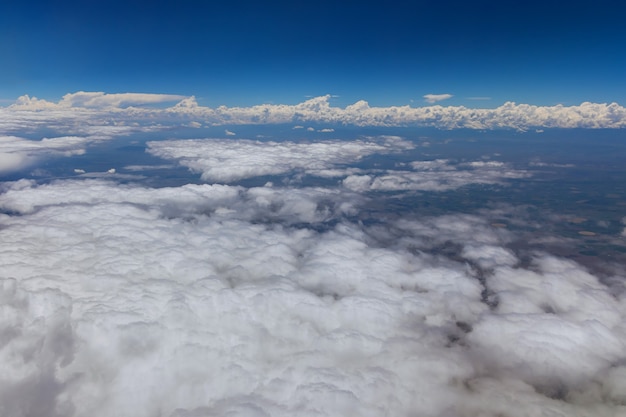 Scenic landscape of overview in desert Arizona from the plane of fluffy clouds in mountains an airplane