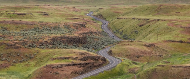 Scenic road in the countryside by green farm fields