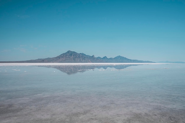 Scenic view of bonneville salt flat and mountains with clear sky in background