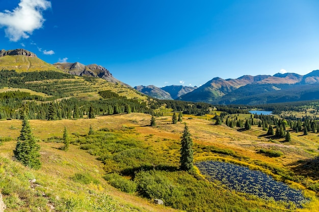 Scenic view of field and mountains against blue sky