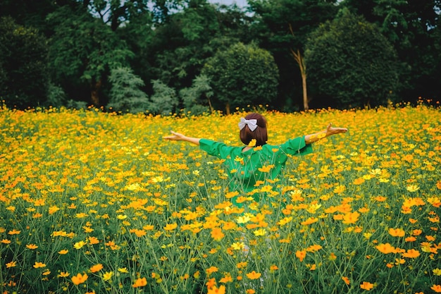 Photo scenic view of a field of vibrant yellow flowers with a person in the distance