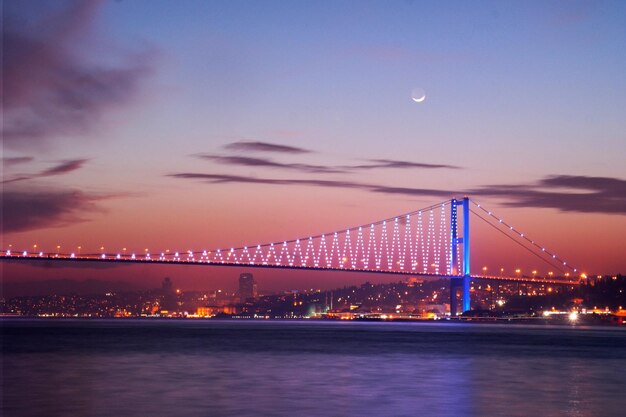 Scenic view of illuminated bosphorus bridge against sky during sunset