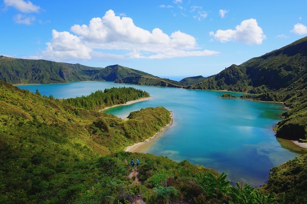 Scenic view of lagoa do fogo at green mountains against sky