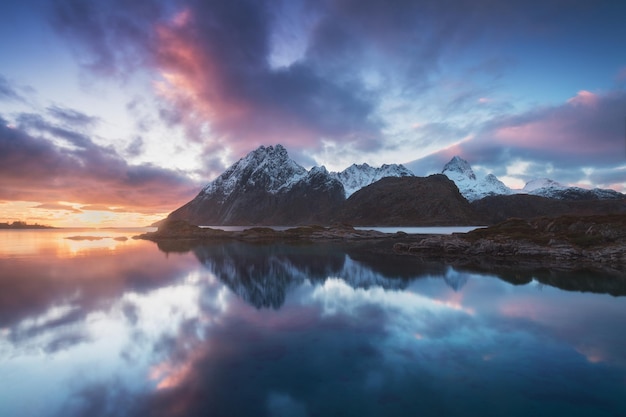 Scenic view of lake by mountains against sky during sunset