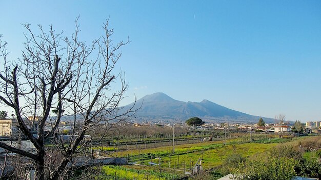 Photo scenic view of landscape whit vesuvio against clear blue sky