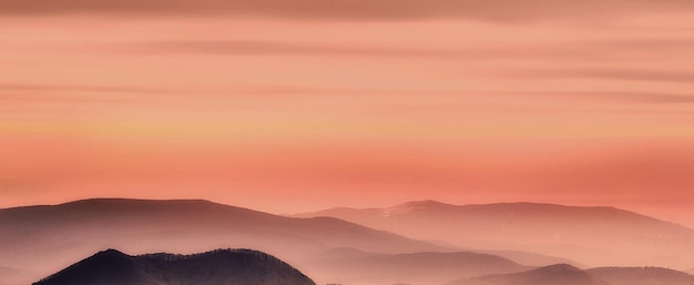 Photo scenic view of mountains against sky during sunset