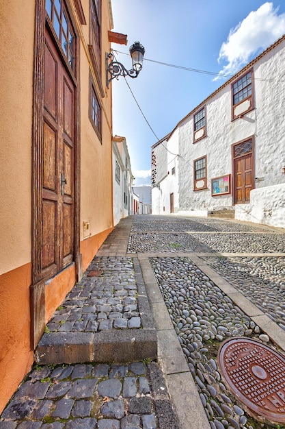 Scenic view of old historic houses residential buildings traditional infrastructure in cobblestone alleyway in a city street or road Travel destination in Santa Cruz La Palma Spain