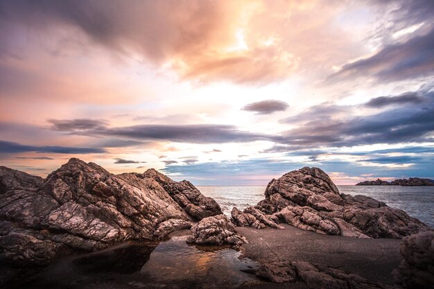 Photo scenic view of rock formation against sky during sunset