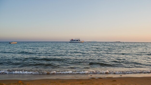 Photo scenic view of sea against clear sky during sunset