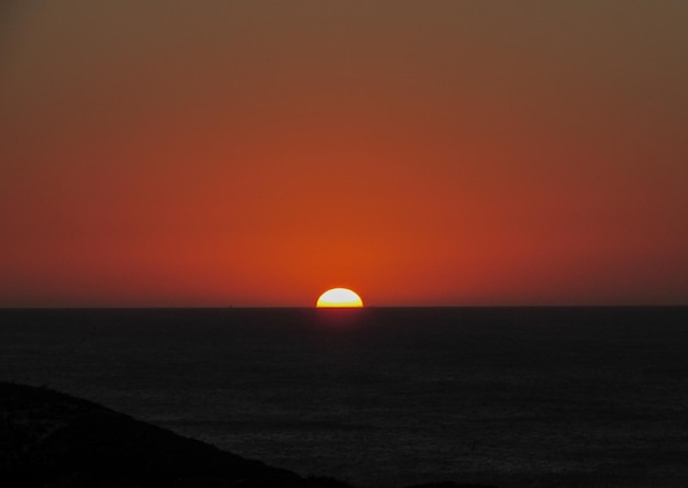 Scenic view of sea against orange sky